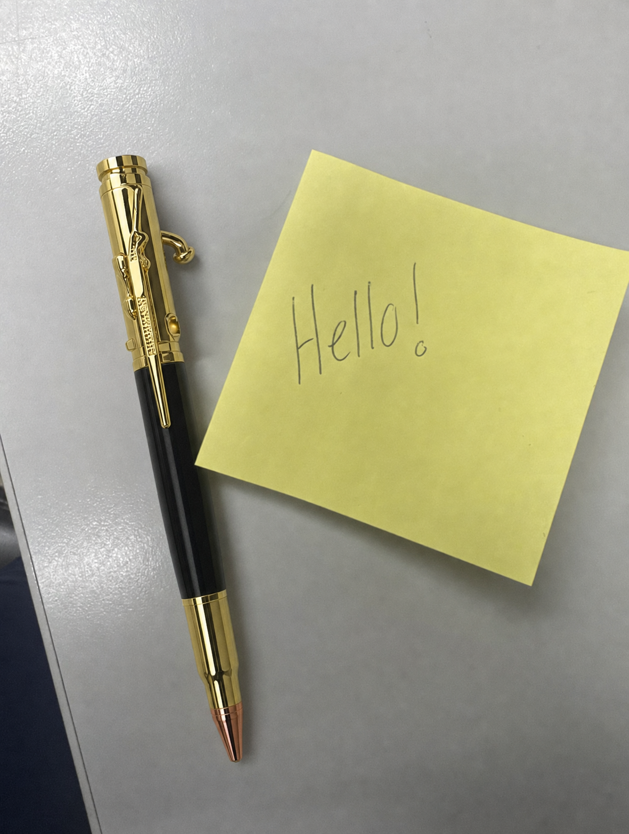 Gold and black pen beside a handwritten note