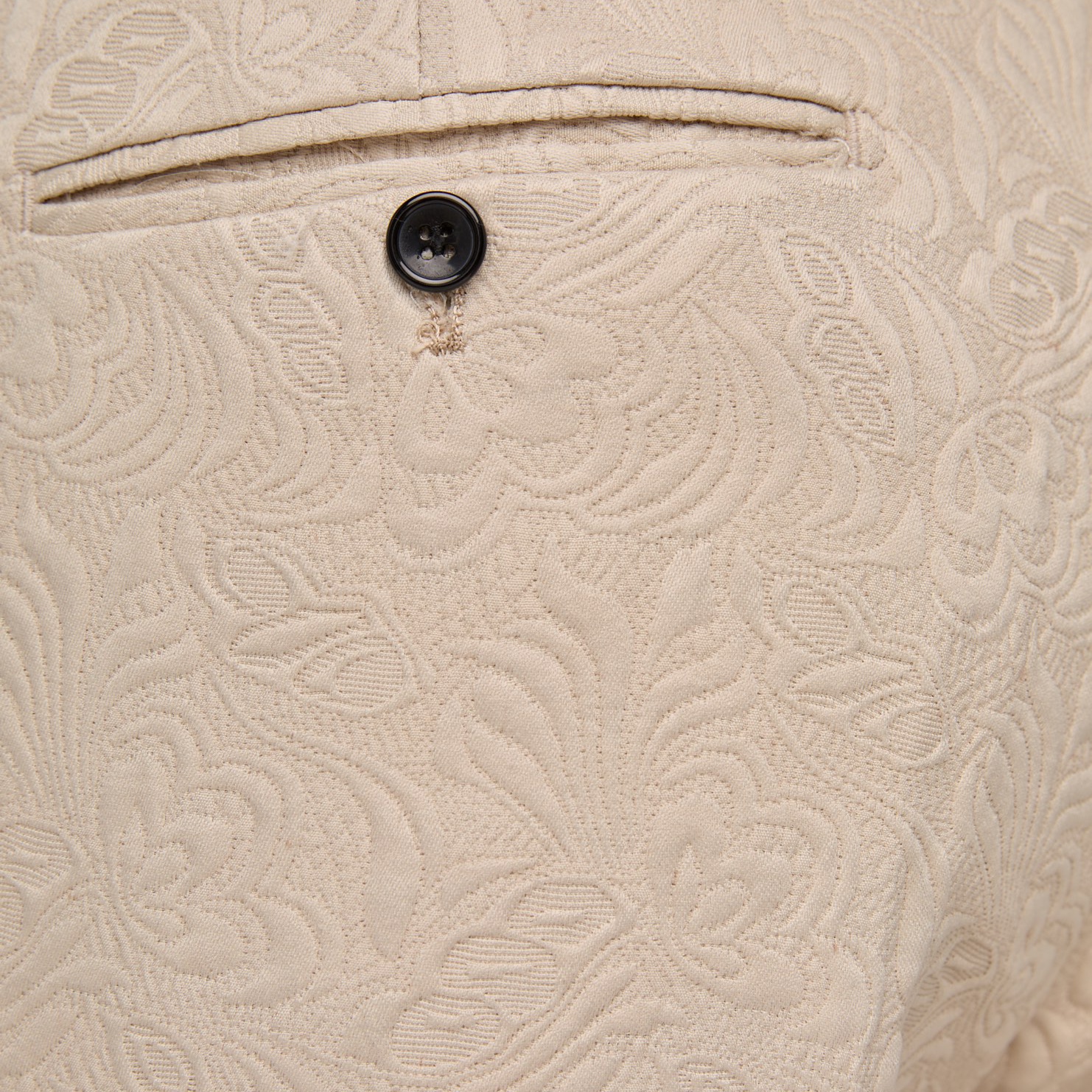 Front view of a men's beige jacquard double-breasted suit with black satin shawl lapel and matching trousers.