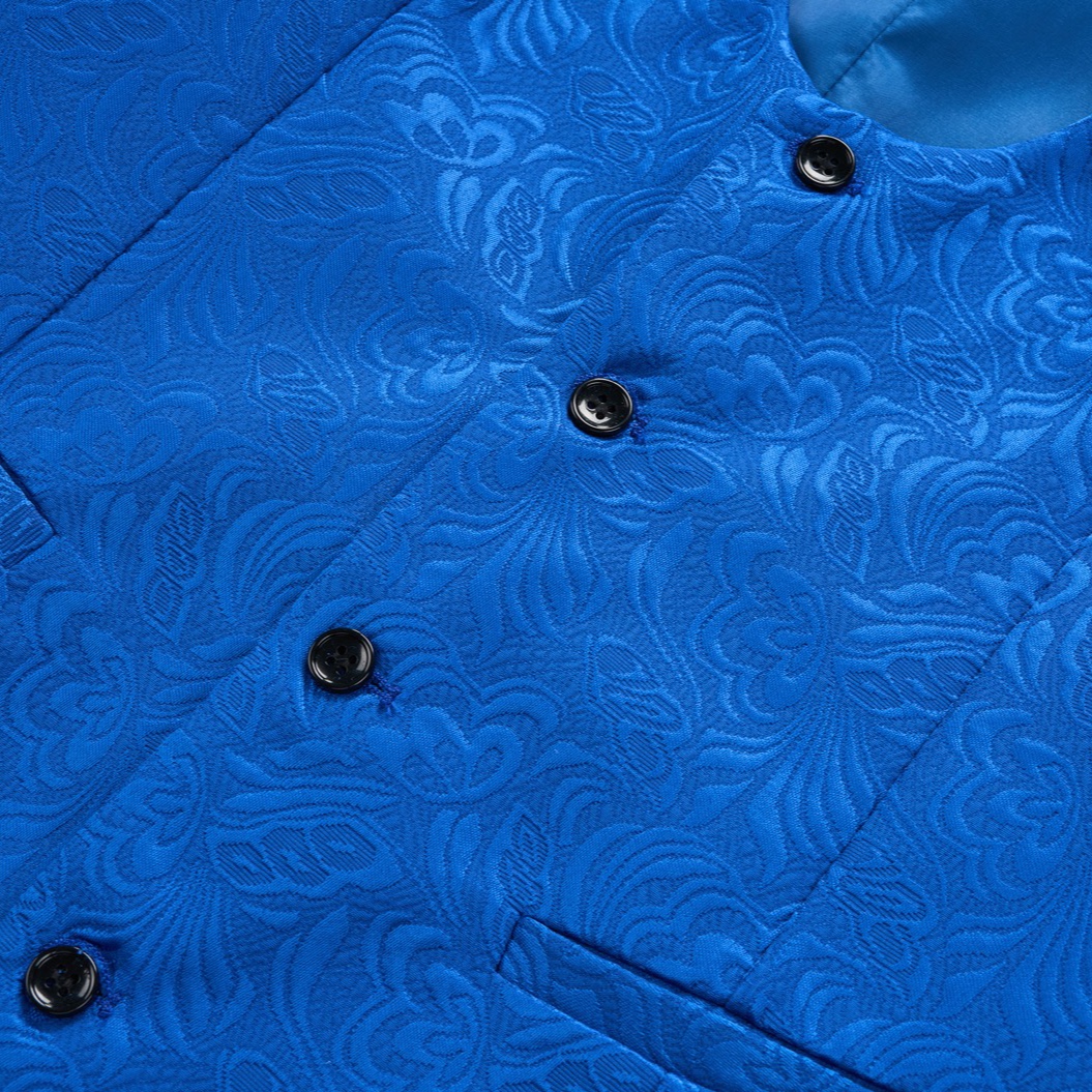 Back view of a vibrant blue jacquard suit jacket with a black velvet shawl collar and intricate floral pattern.