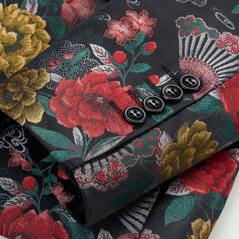 Front view of a men's black jacquard blazer with vibrant red, gold, and green floral and peacock feather patterns.
