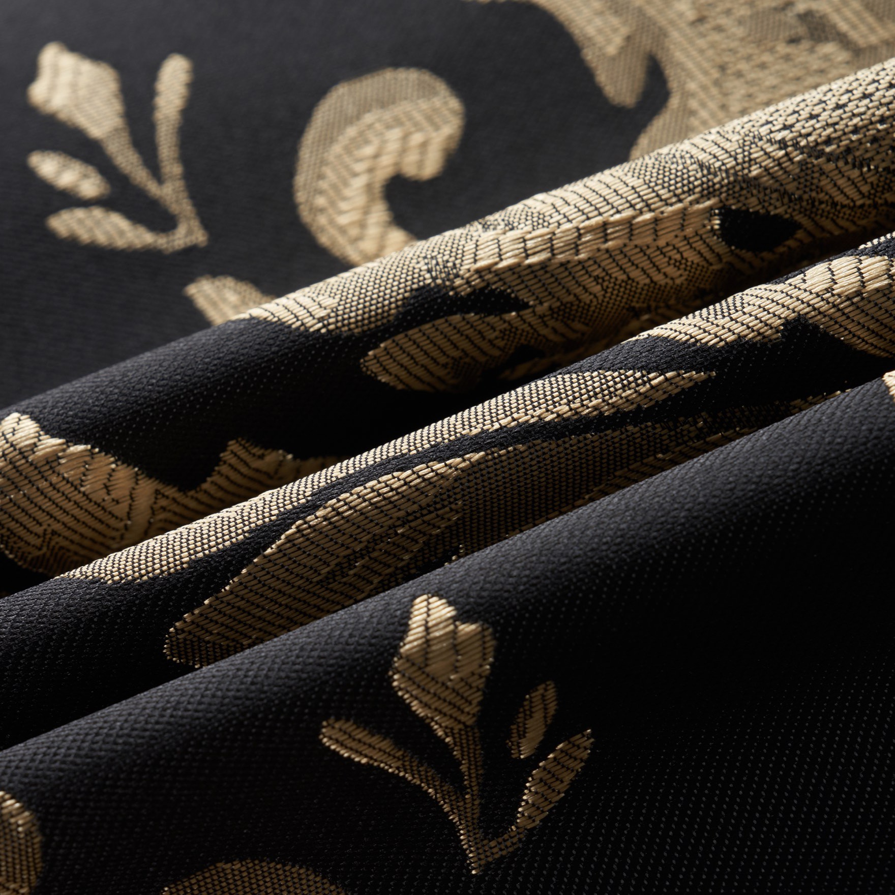 Front view of a men's black and gold damask patterned blazer with a black satin shawl lapel and one button closure.