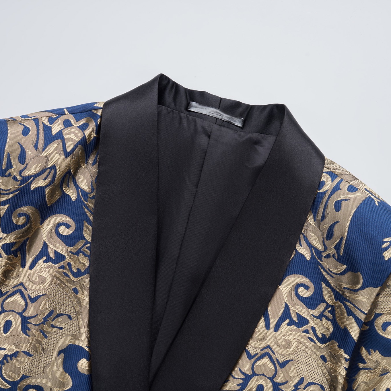 Front view of a men's blue and gold damask patterned blazer with black shawl lapels, one-button closure, and black trim