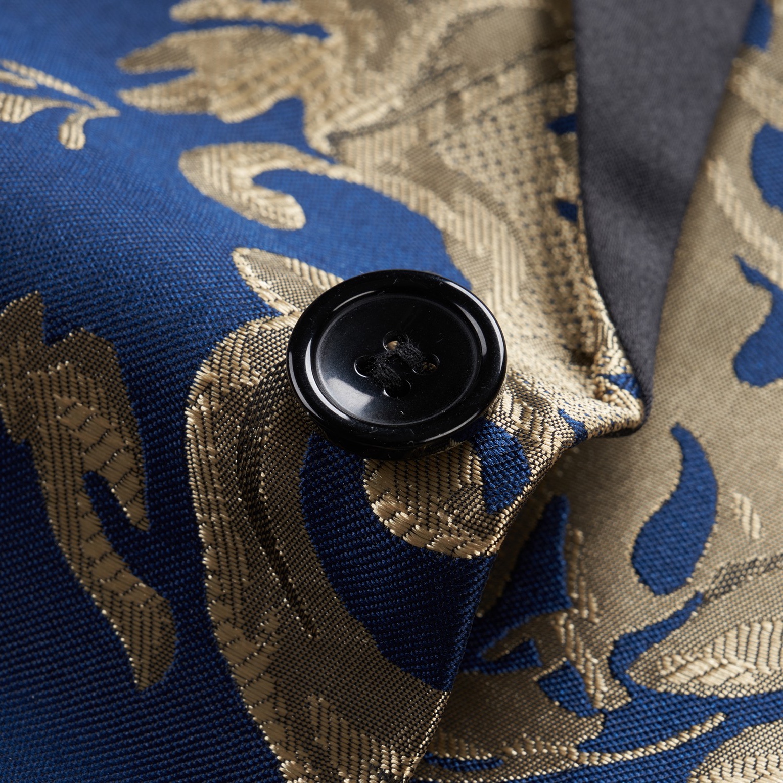 Front view of a men's blue and gold damask patterned blazer with black shawl lapels, one-button closure, and black trim
