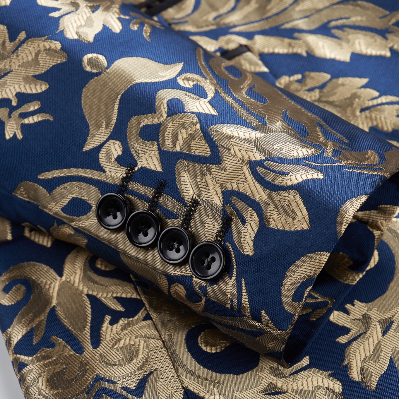 Front view of a men's blue and gold damask patterned blazer with black shawl lapels, one-button closure, and black trim