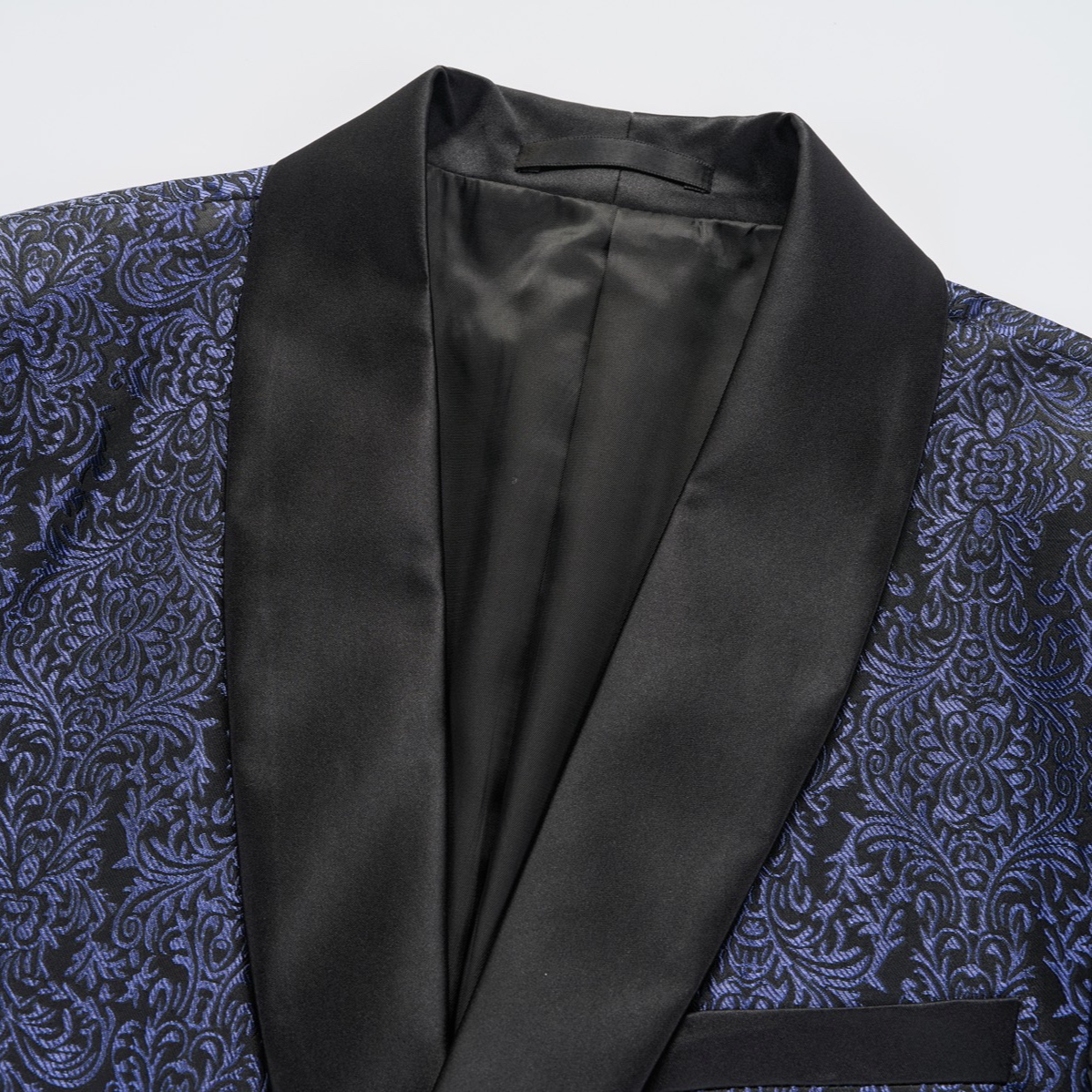 Front view of a men's black and navy damask pattern dinner jacket with a black satin shawl lapel and one-button closure.