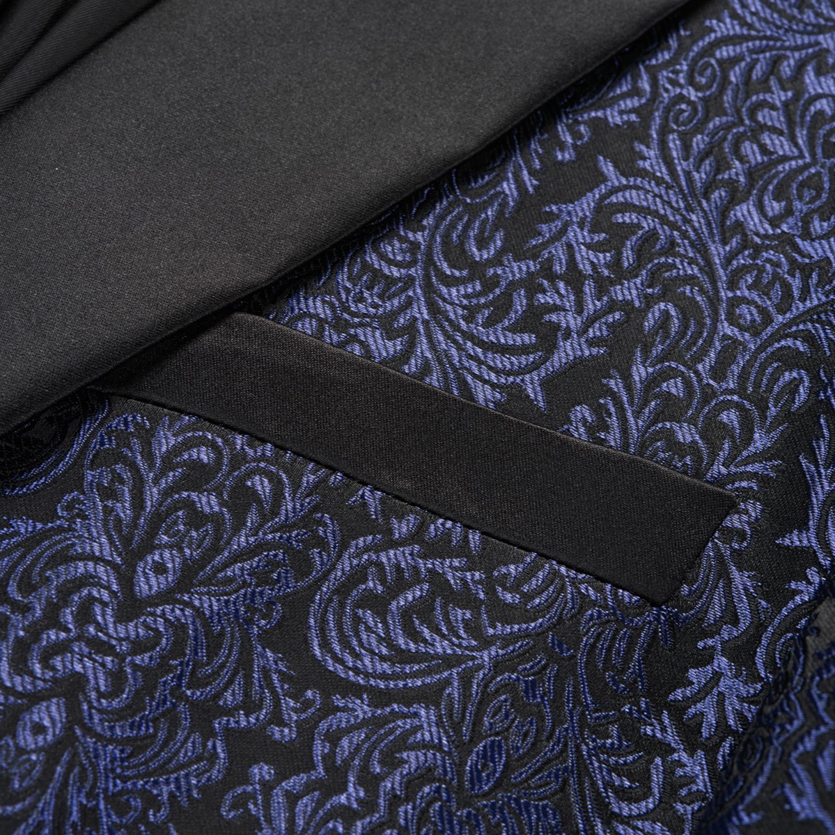 Front view of a men's black and navy damask pattern dinner jacket with a black satin shawl lapel and one-button closure.