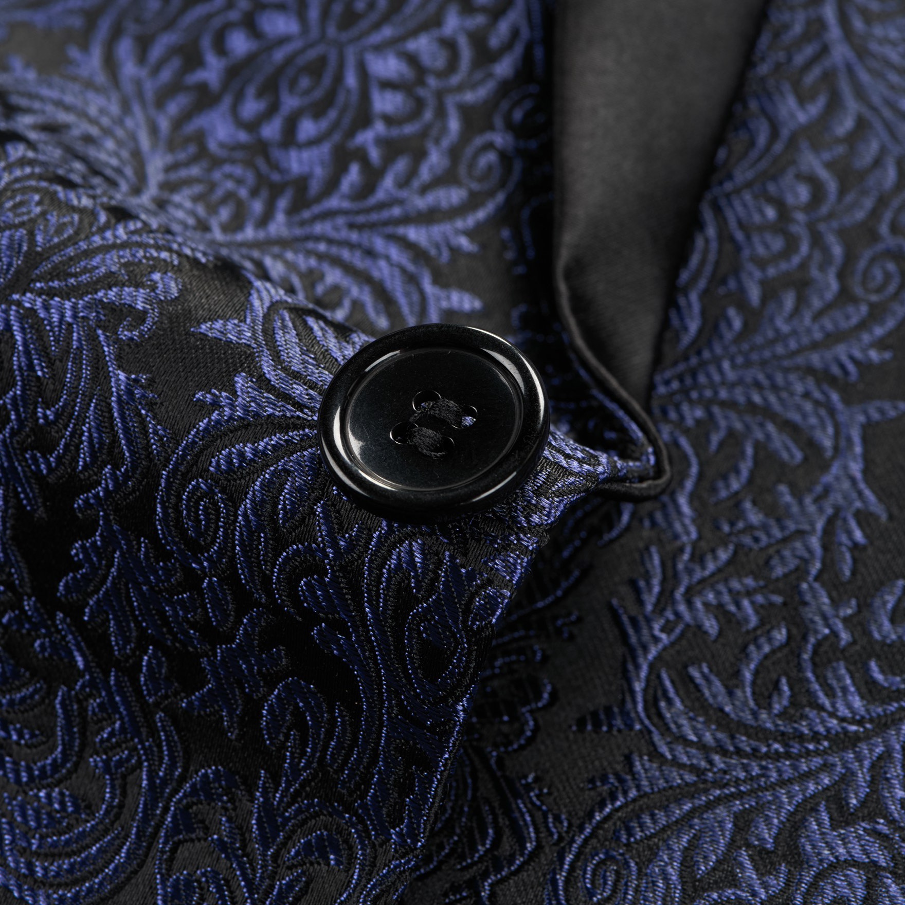 Front view of a men's black and navy damask pattern dinner jacket with a black satin shawl lapel and one-button closure.