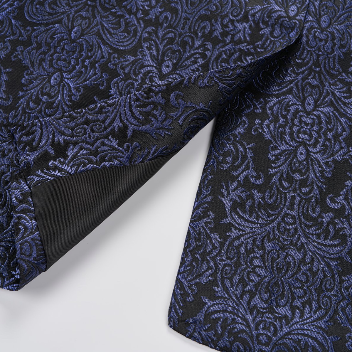 Front view of a men's black and navy damask pattern dinner jacket with a black satin shawl lapel and one-button closure.