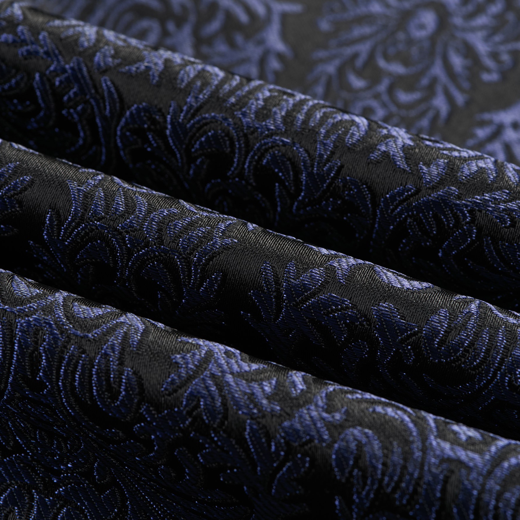 Front view of a men's black and navy damask pattern dinner jacket with a black satin shawl lapel and one-button closure.