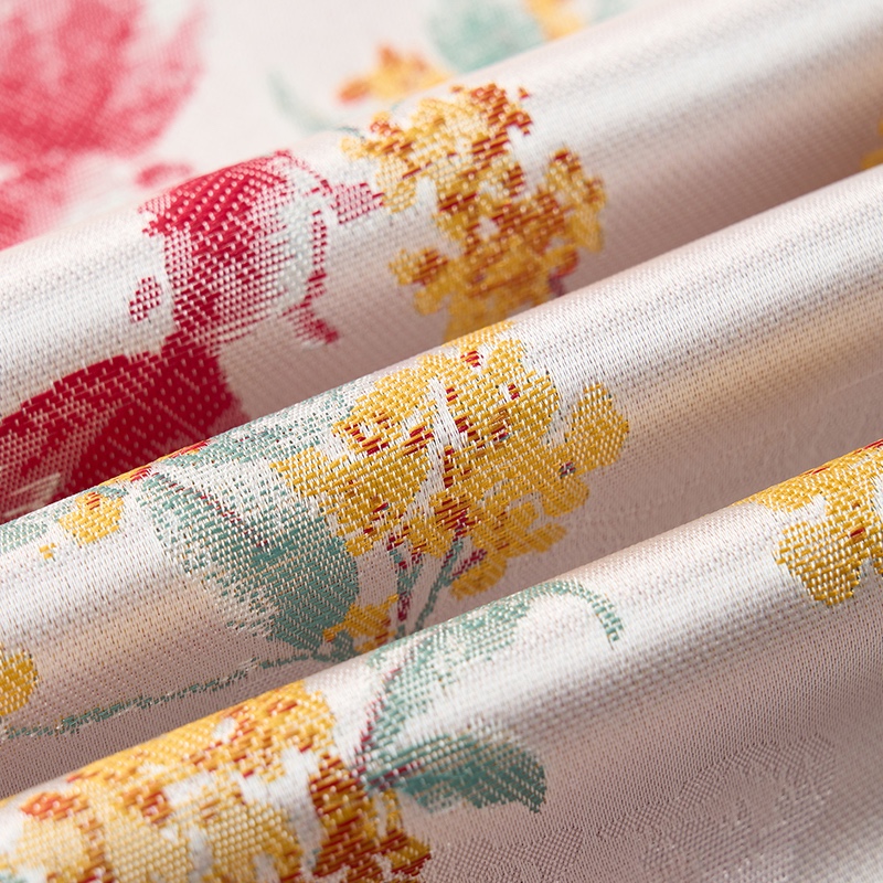 Close-up of a men's white jacquard suit jacket with red, yellow, and green floral patterns, showing the one-button closure