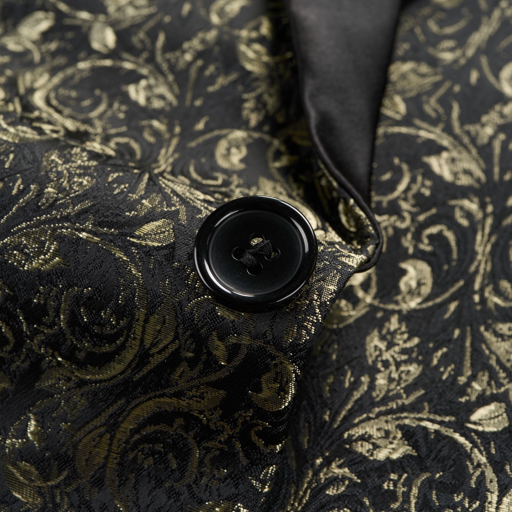Front view of a men's black tuxedo jacket with gold floral jacquard pattern and black satin shawl lapel.