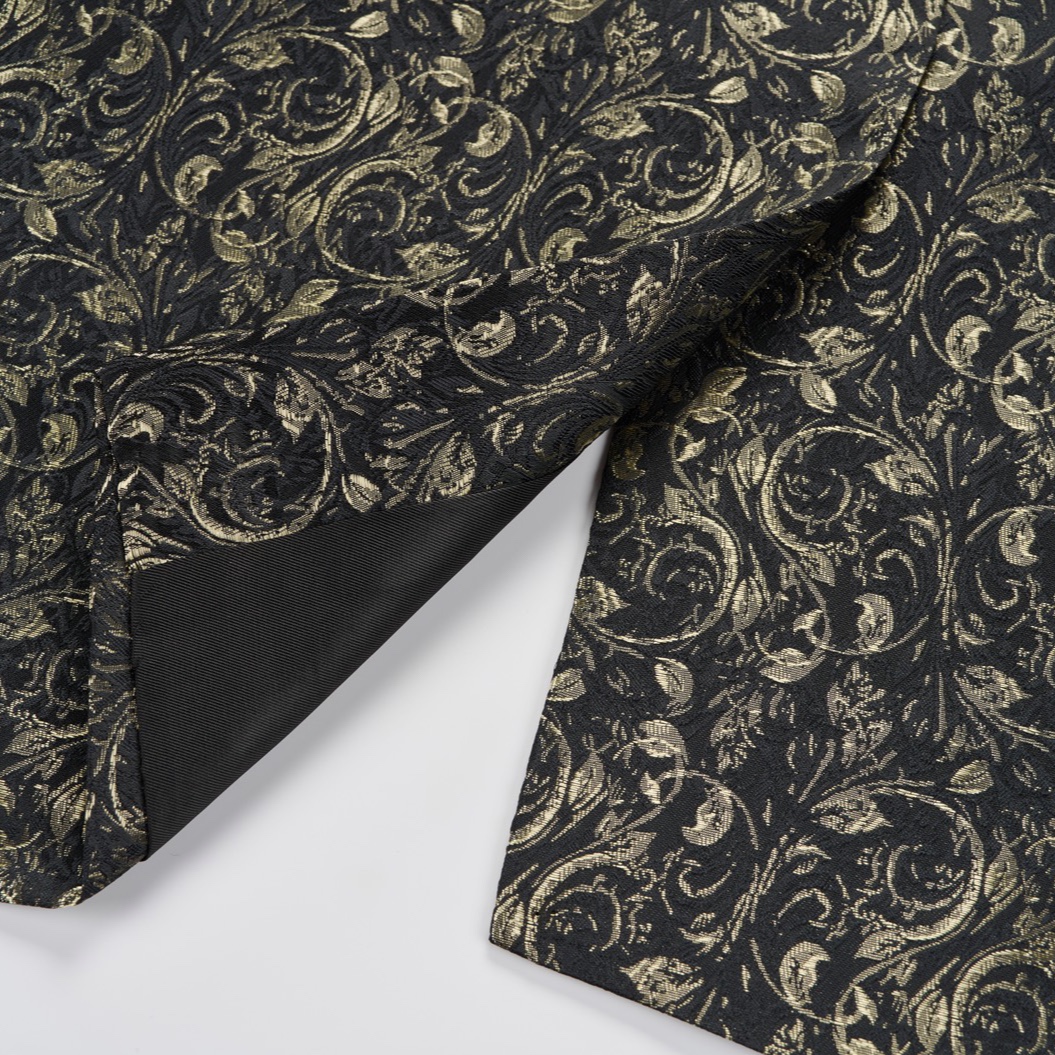 Front view of a men's black tuxedo jacket with gold floral jacquard pattern and black satin shawl lapel.