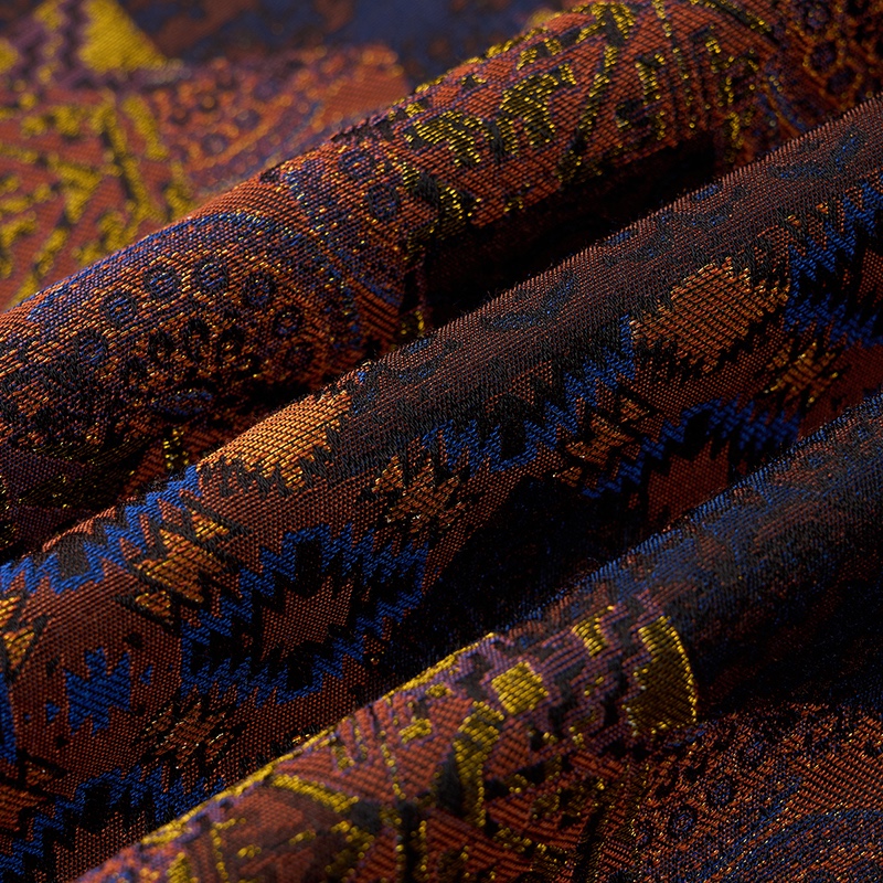 Close-up of a men's brown, blue, and gold abstract patterned jacquard suit jacket with one button closure and four-button