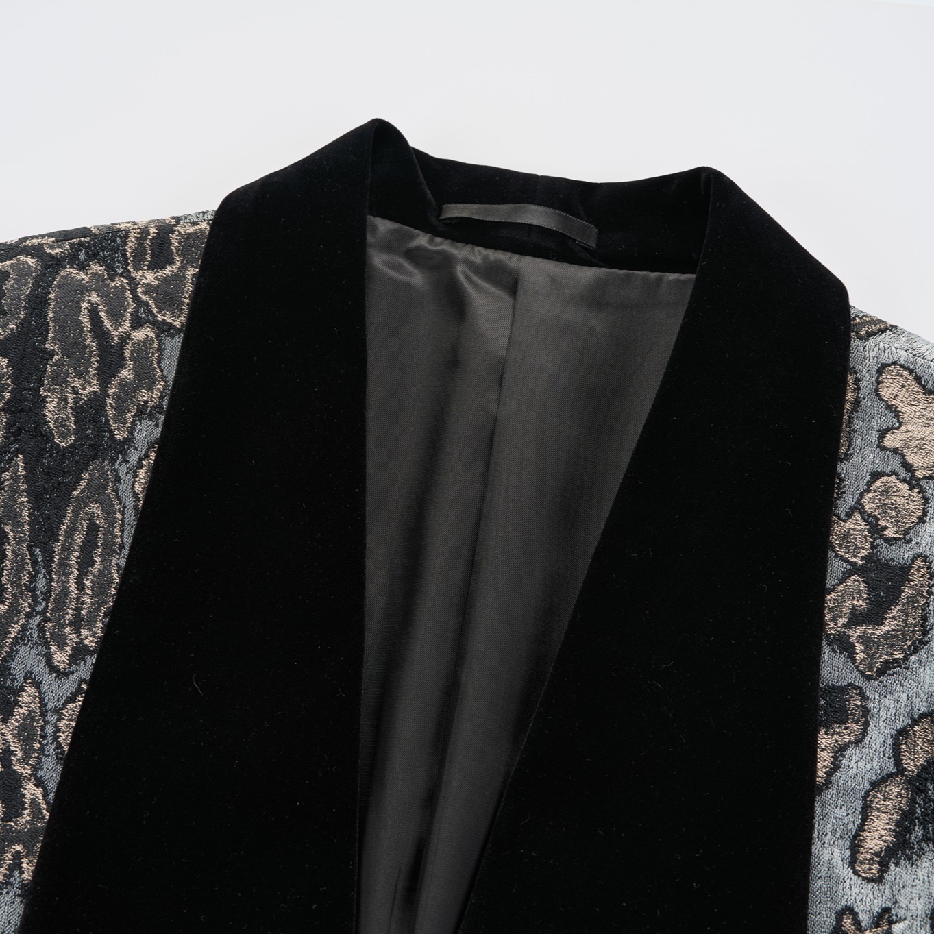 Front view of a men's black, gold, and grey leopard print tuxedo jacket with a black velvet shawl lapel and one-button