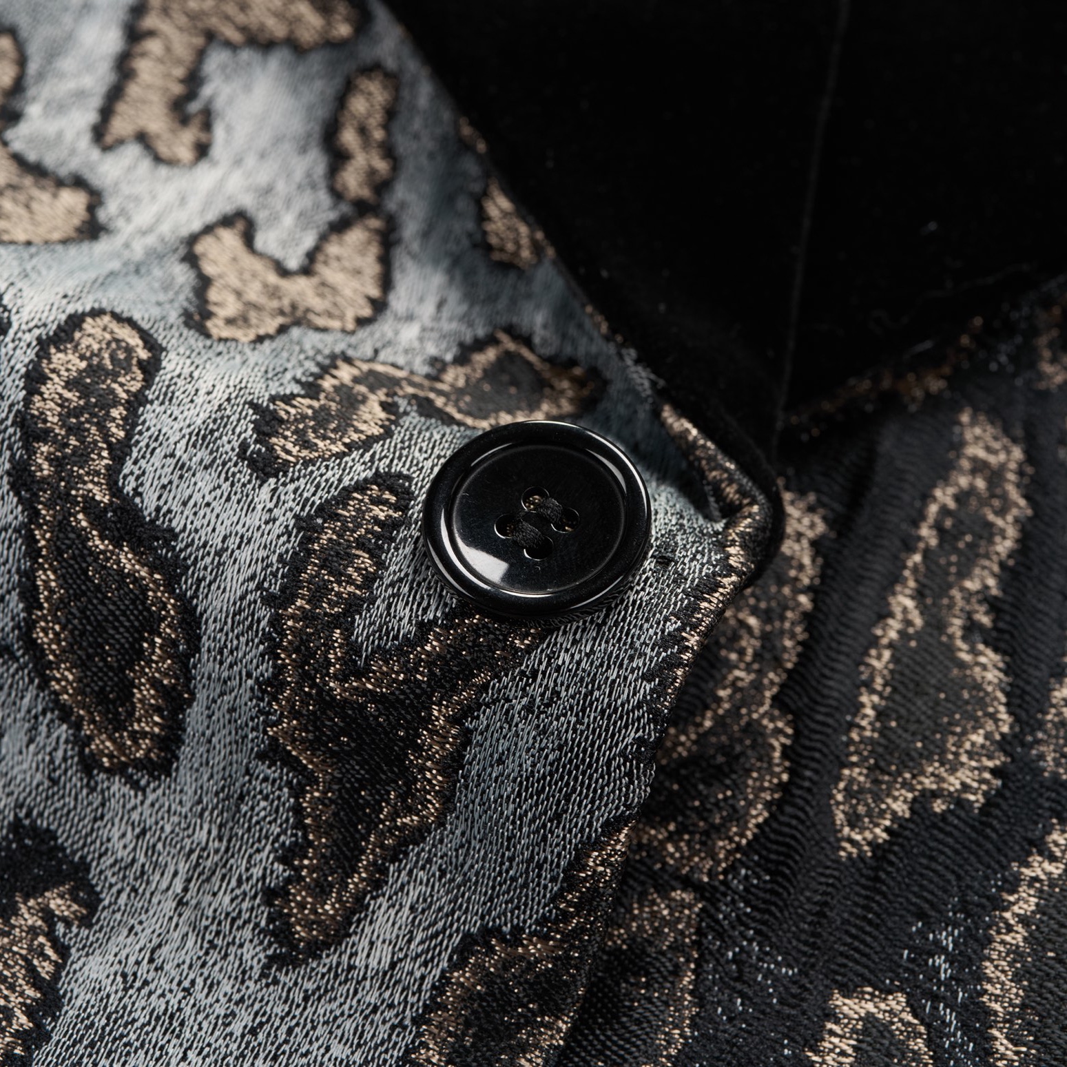 Front view of a men's black, gold, and grey leopard print tuxedo jacket with a black velvet shawl lapel and one-button