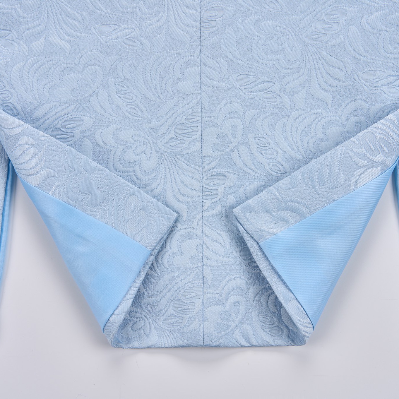 Front view of a men's light blue double-breasted blazer with a floral jacquard pattern and black shawl lapel.