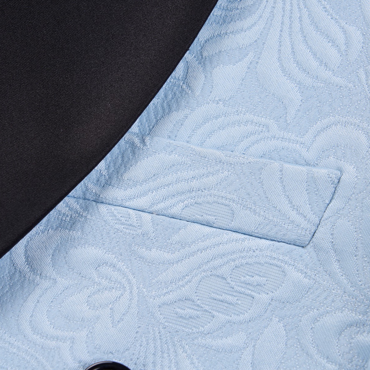 Front view of a men's light blue double-breasted blazer with a floral jacquard pattern and black shawl lapel.