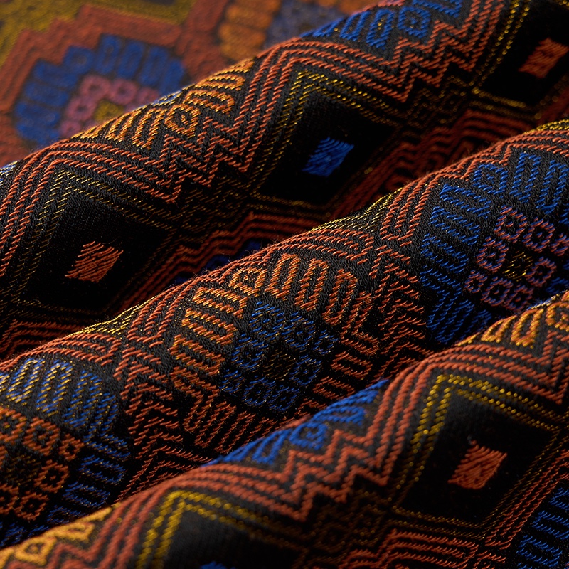 Front view of a men's brown, blue, and orange geometric jacquard blazer with one button closure.
