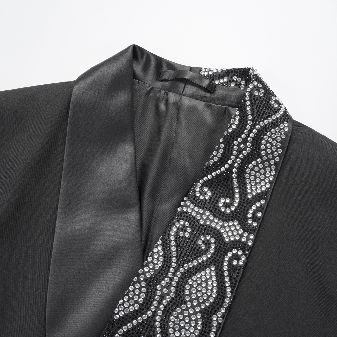 Front view of a men's black double-breasted tuxedo jacket with sequin-embellished shawl lapels, scattered rhinestones on the