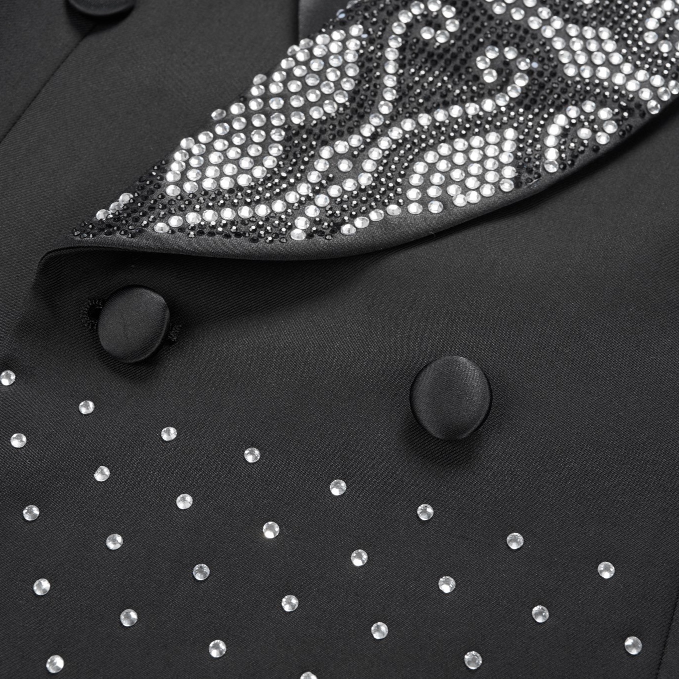Front view of a men's black double-breasted tuxedo jacket with sequin-embellished shawl lapels, scattered rhinestones on the