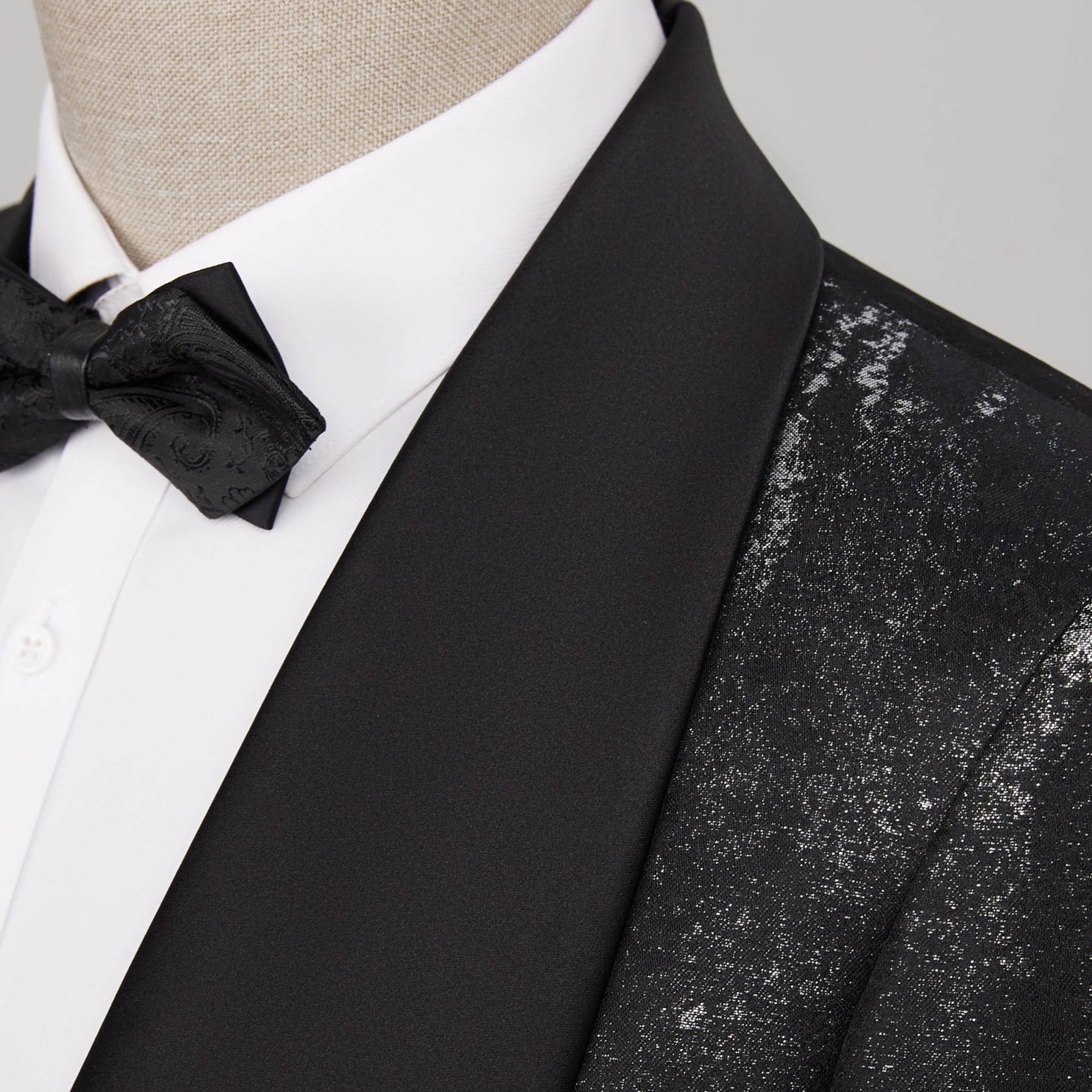 Back view of a men's black suit jacket with silver distressed metallic print
