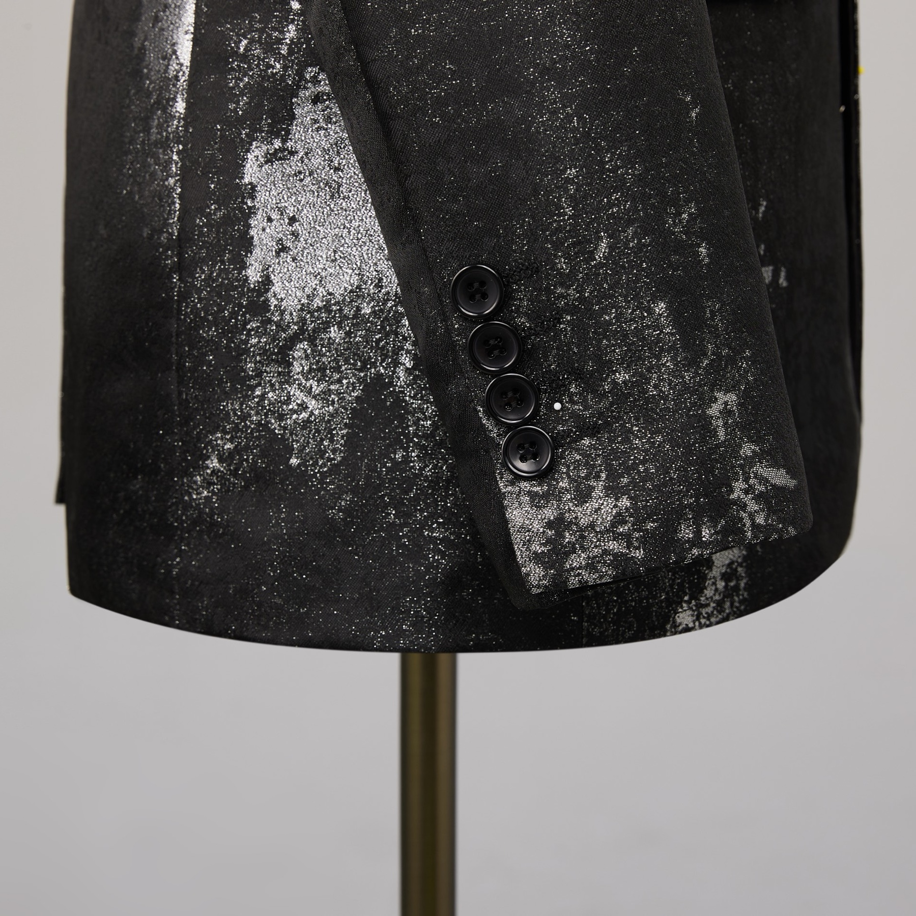 Back view of a men's black suit jacket with silver distressed metallic print