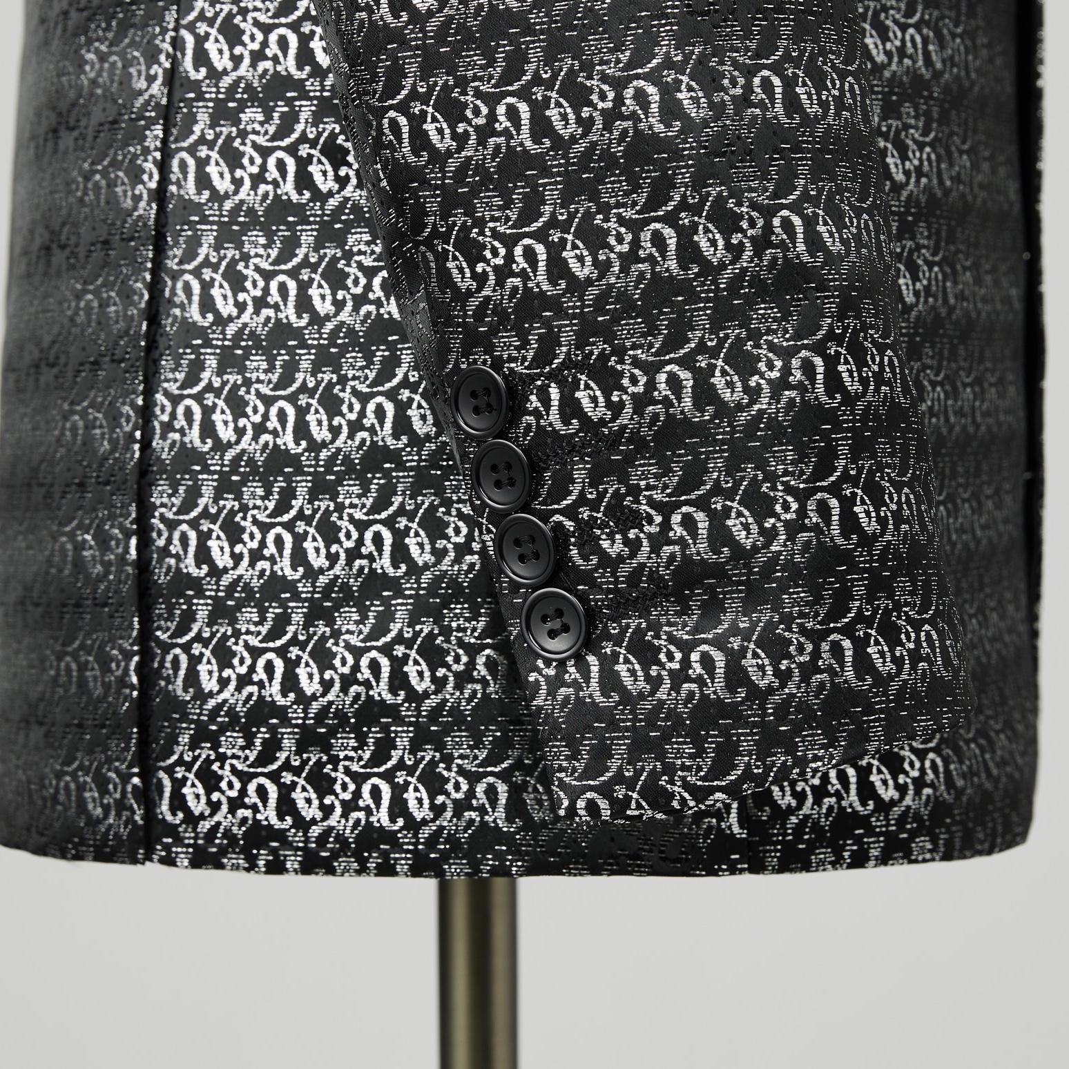 Front view of a men's black and silver patterned tuxedo jacket with a satin shawl lapel.