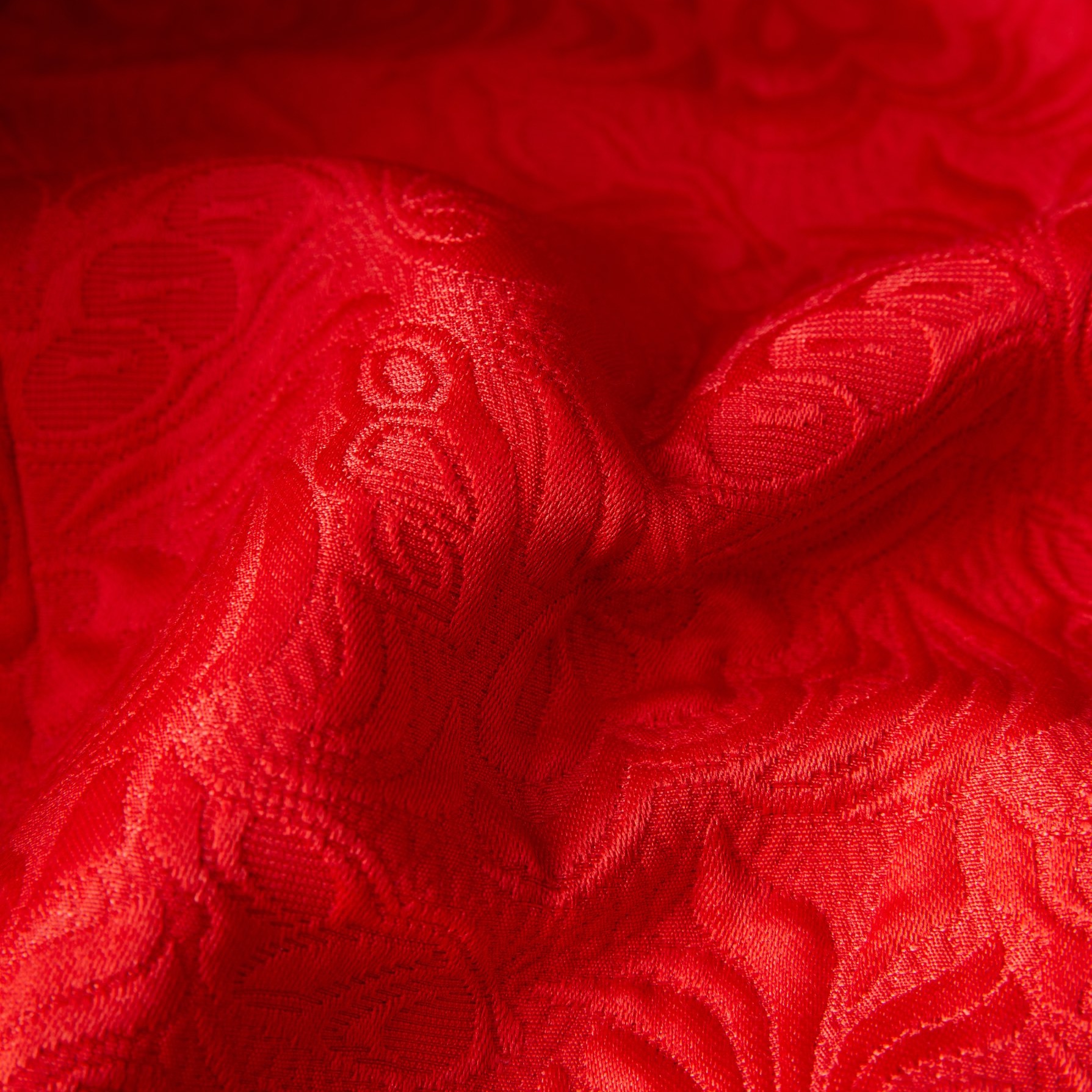 Back view of a men's red floral jacquard blazer with a black shawl lapel and sleeve buttons.