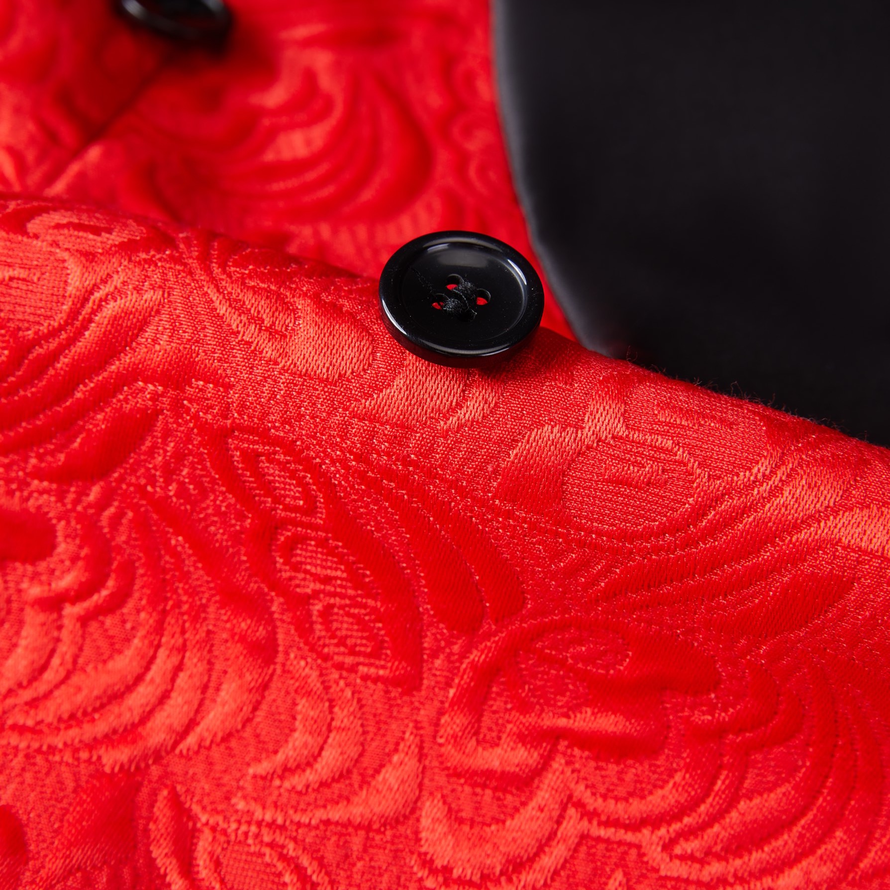 Front view of a men's red jacquard double-breasted suit with black shawl lapels and matching pants.
