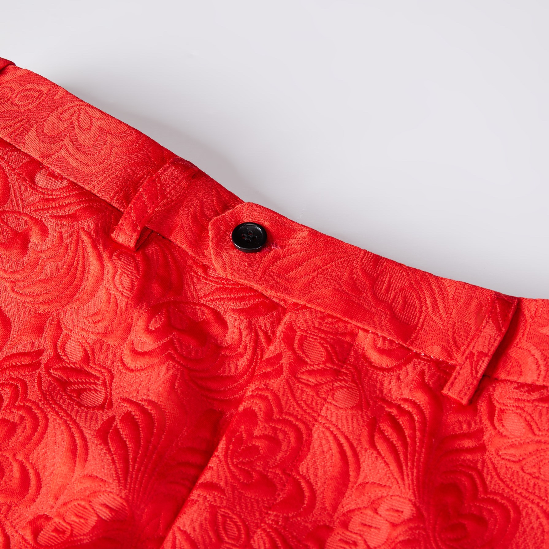Front view of a men's red jacquard double-breasted suit with black shawl lapels and matching pants.
