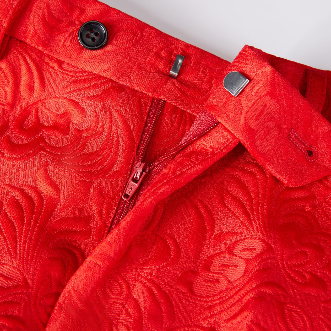 Front view of a men's red jacquard double-breasted suit with black shawl lapels and matching pants.