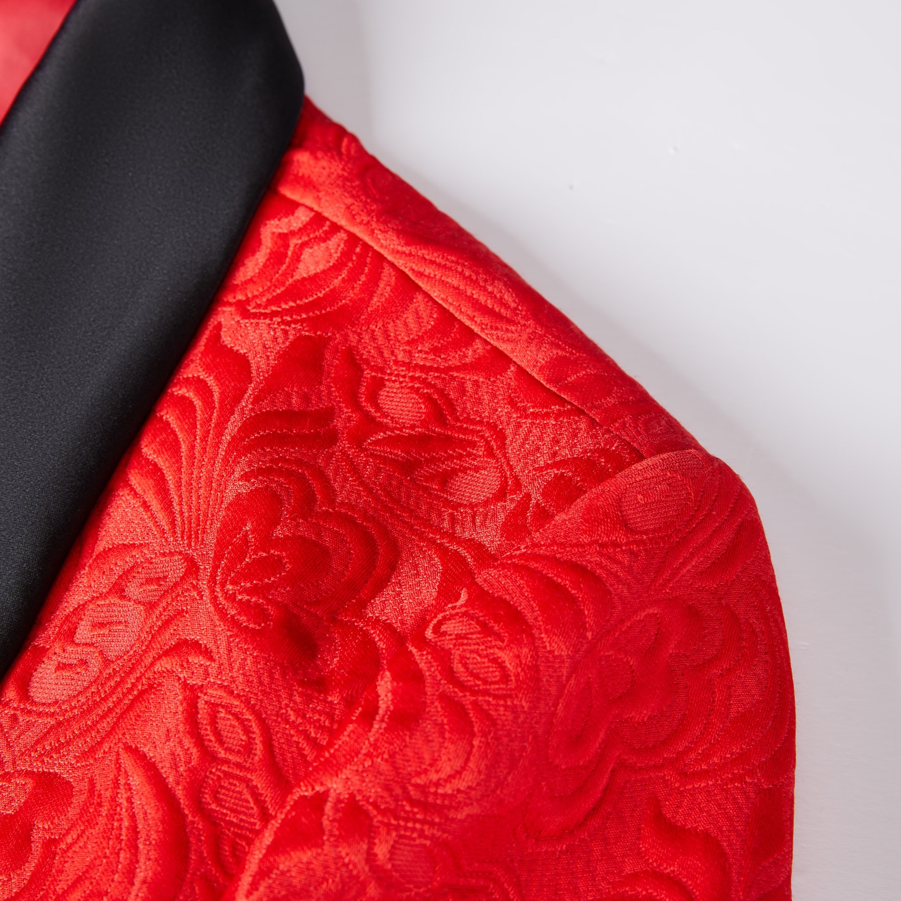 Front view of a men's red jacquard double-breasted suit with black shawl lapels and matching pants.