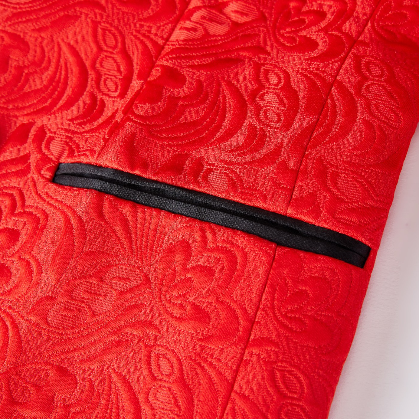 Back view of a men's red floral jacquard blazer with a black shawl lapel and sleeve buttons.