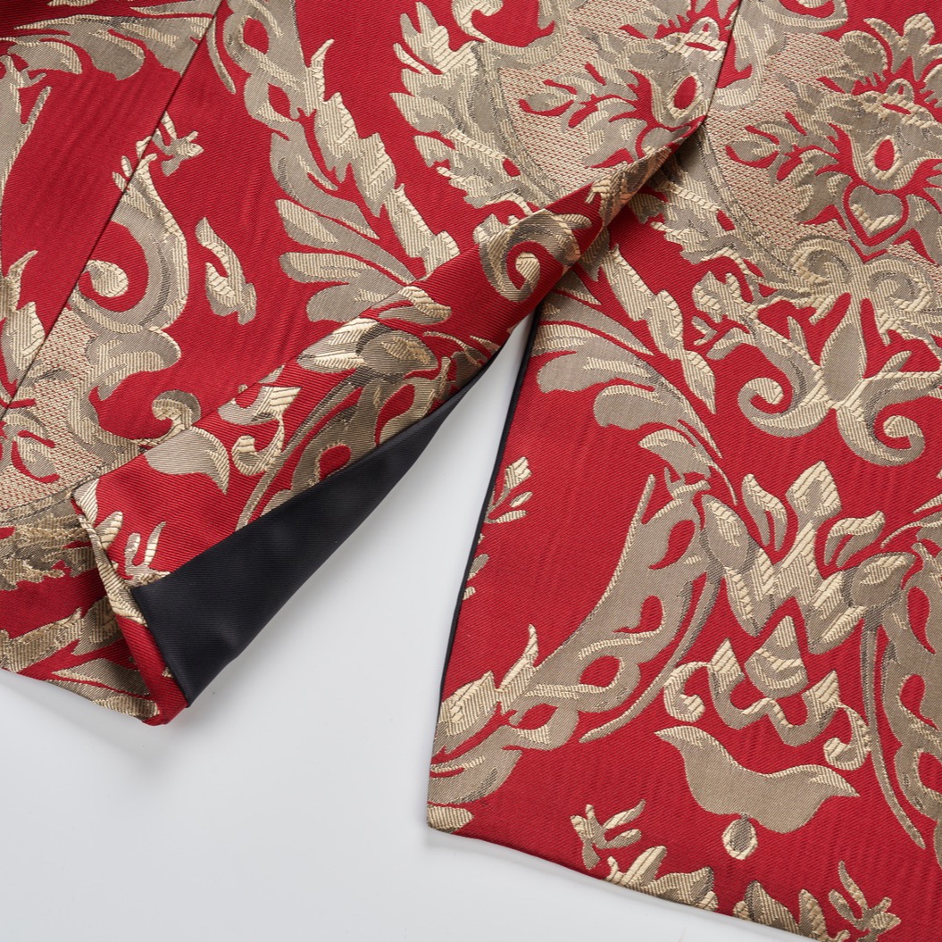 Front view of a men's red and gold jacquard patterned tuxedo jacket with black shawl lapel and one button closure.