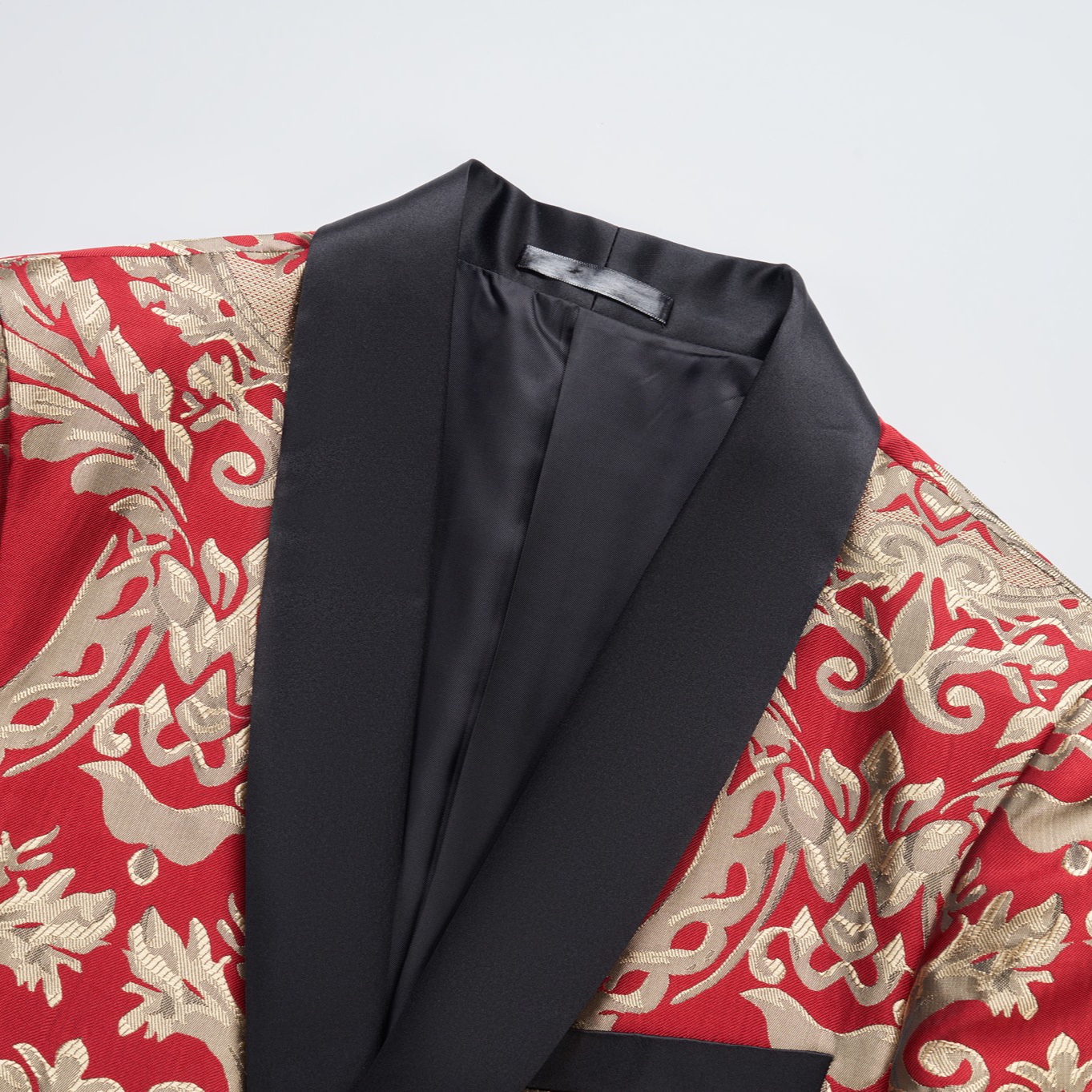 Front view of a men's red and gold jacquard patterned tuxedo jacket with black shawl lapel and one button closure.
