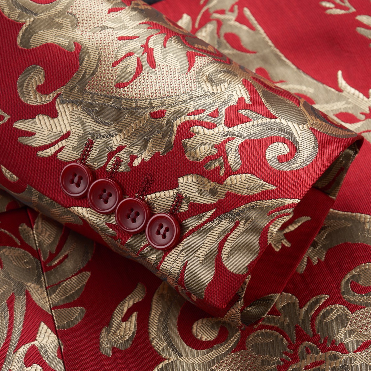 Front view of a men's red and gold jacquard patterned tuxedo jacket with black shawl lapel and one button closure.