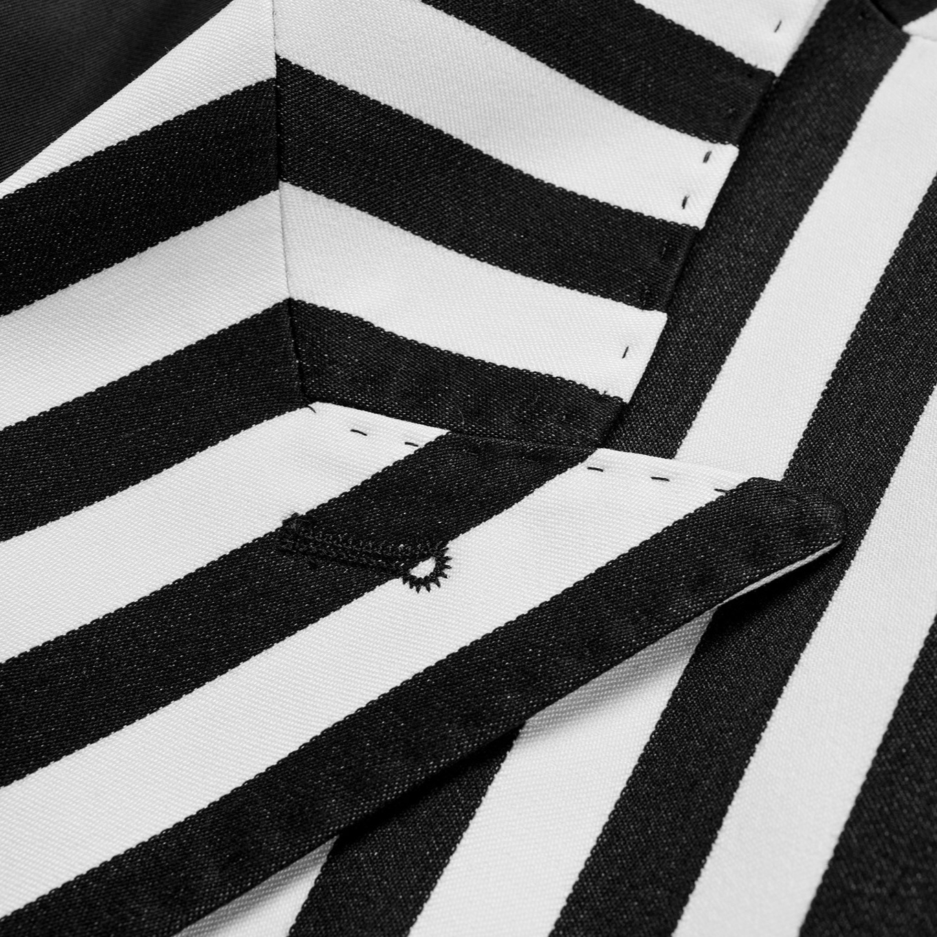 Close-up of a men's black and white striped double-breasted suit with peak lapels and button details.