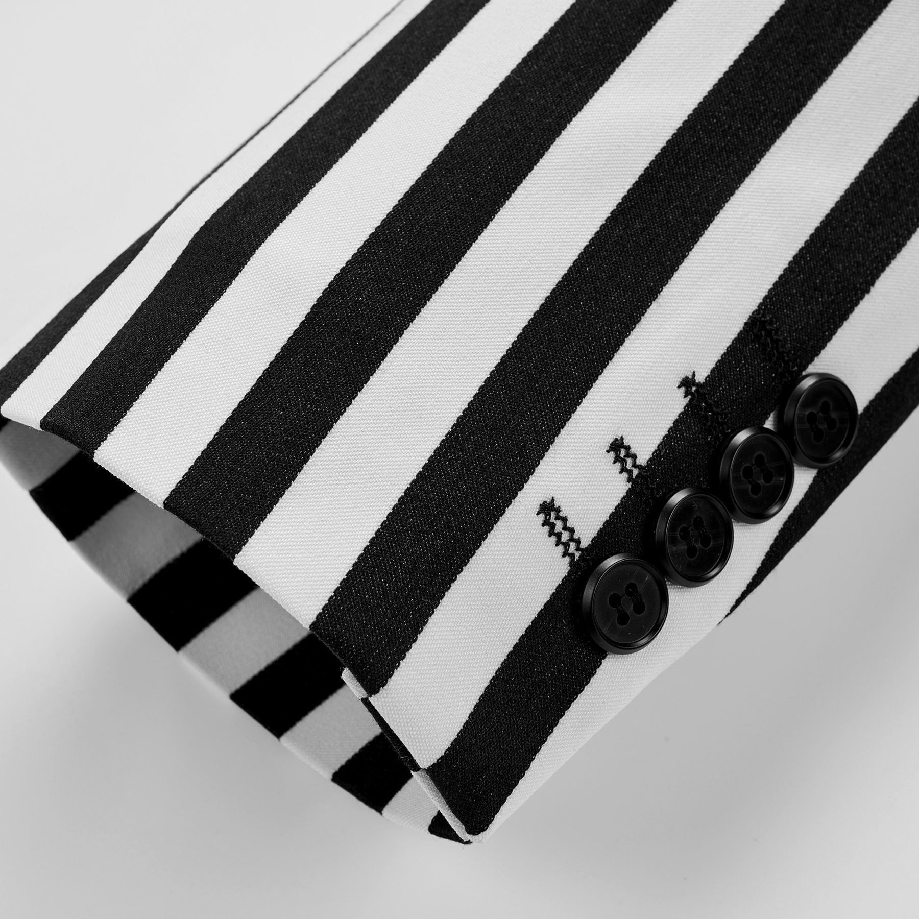 Close-up of a men's black and white striped double-breasted suit with peak lapels and button details.