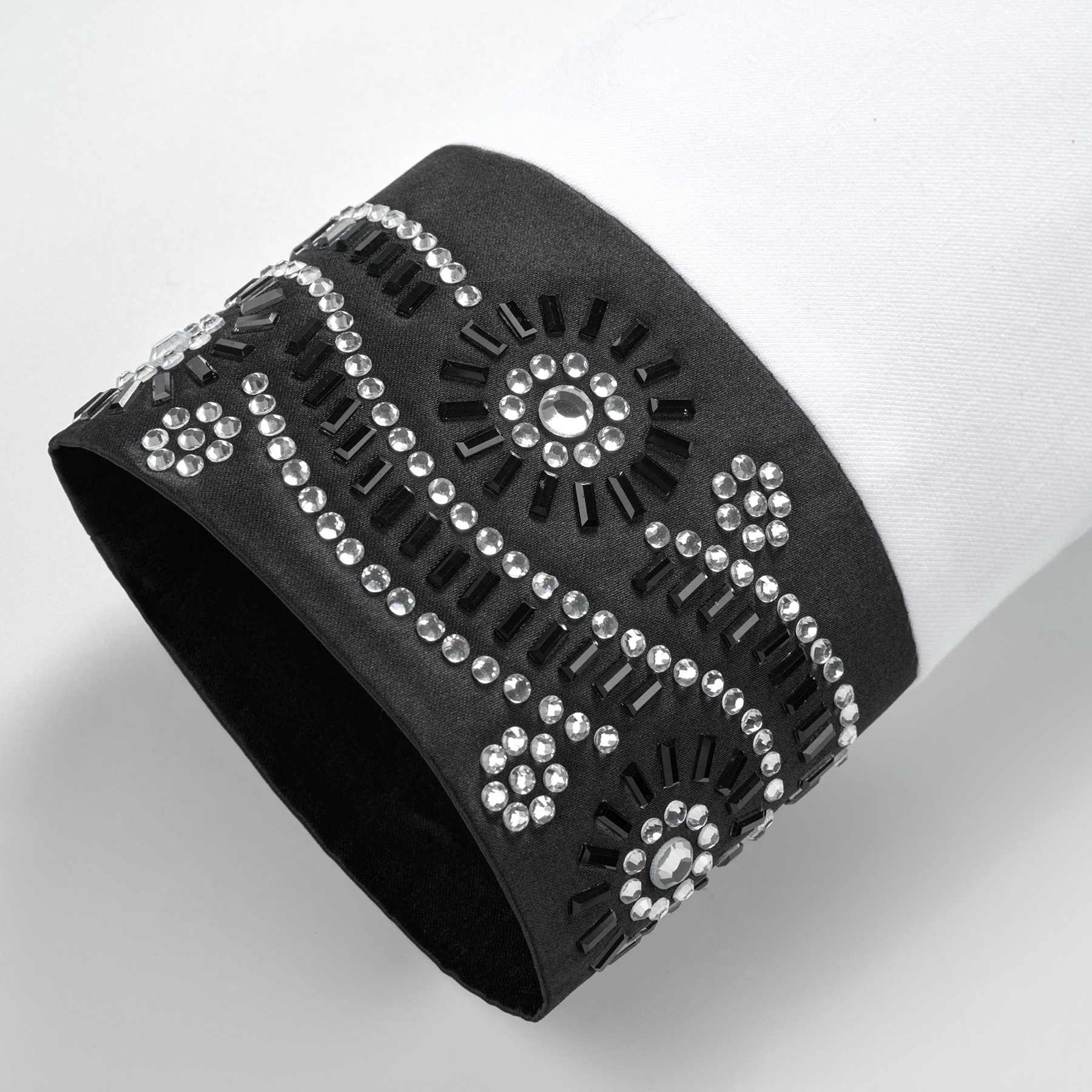 Front view of a white double-breasted suit jacket with black embellished shawl lapels and cuffs featuring rhinestones and