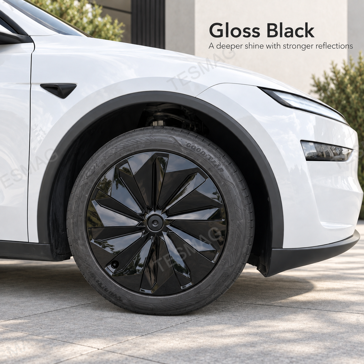 Gloss black 19-inch wheel cover installed on a white Tesla Model Y Juniper