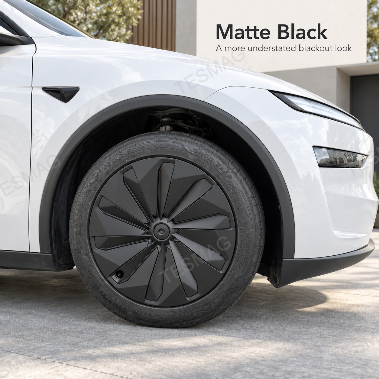 Matte black 19-inch wheel cover installed on a white Tesla Model Y Juniper