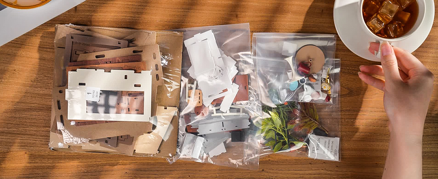 Unassembled Rolife Coffee Shop miniature house pieces laid out on a table