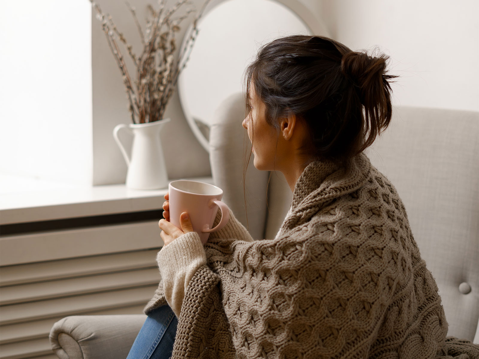 smiling lady smart trendy wear is sitting armchair with cup tea