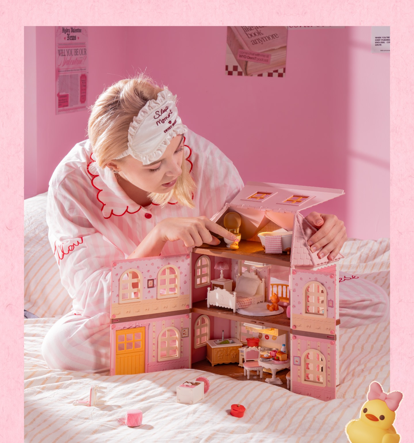 Girl assembling Fairy Rose Cottage DIY Dollhouse on a pink bed