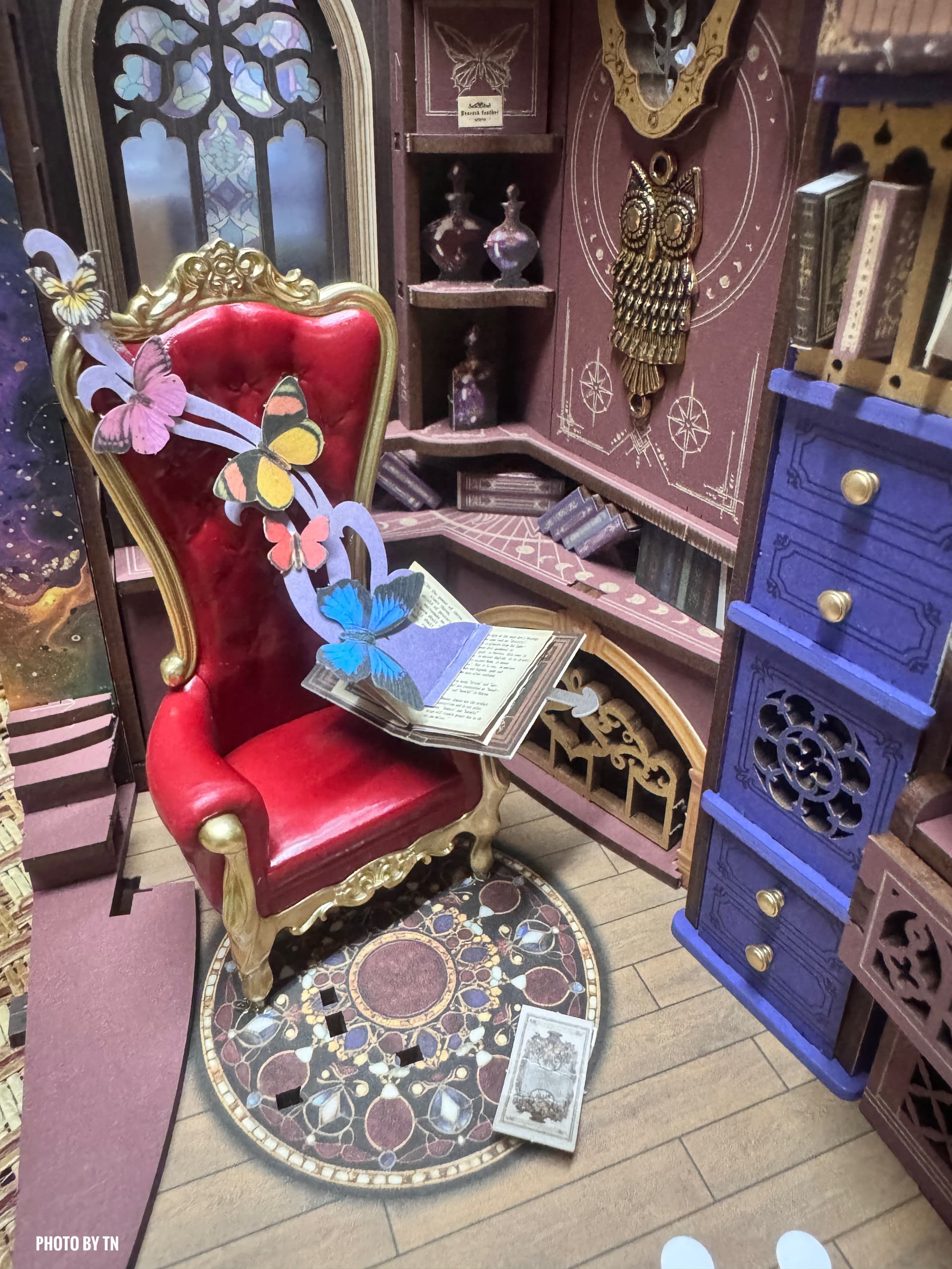 Photo : Intérieur TGB14 de ThaoNguyen montrant la chaise rouge, le livre ouvert, les papillons et les détails du petit cabinet