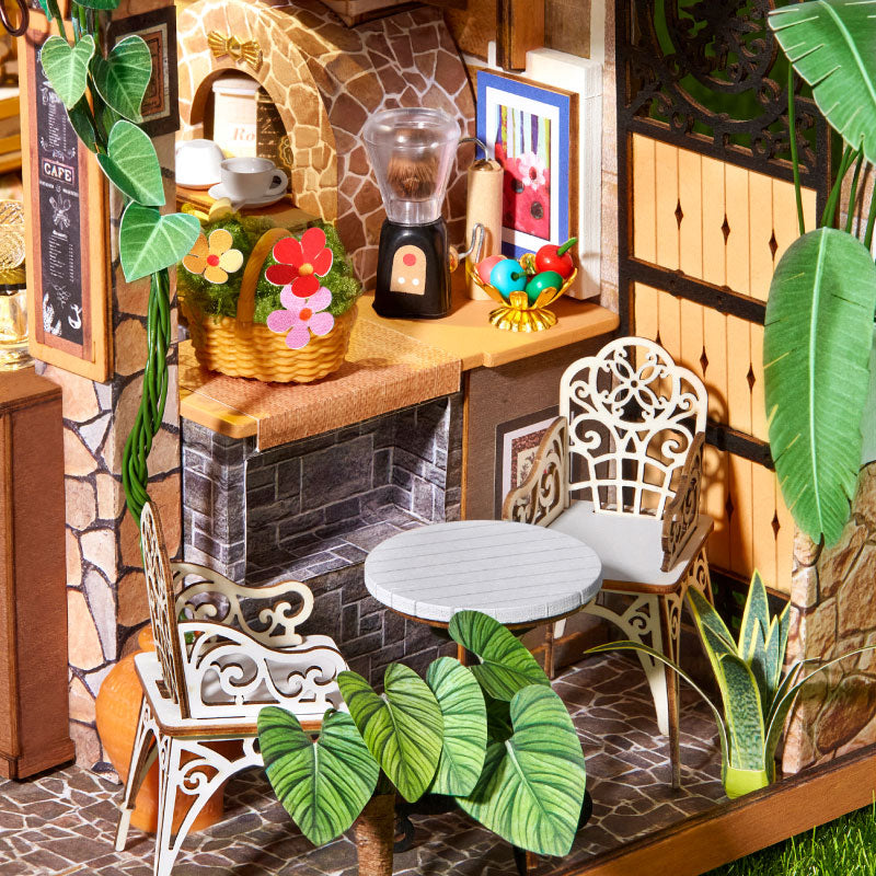 Leafree Café DH201 garden seating area with iron chairs, coffee grinder, flowers, and plants