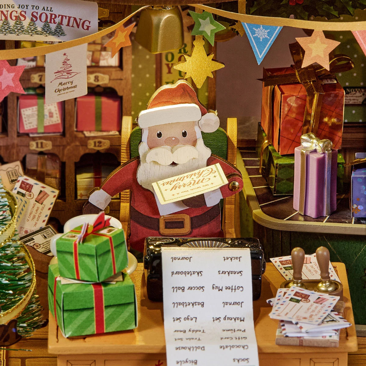 Close-up of Santa at the Polaris Post desk with letters, lists, gifts, and festive bunting