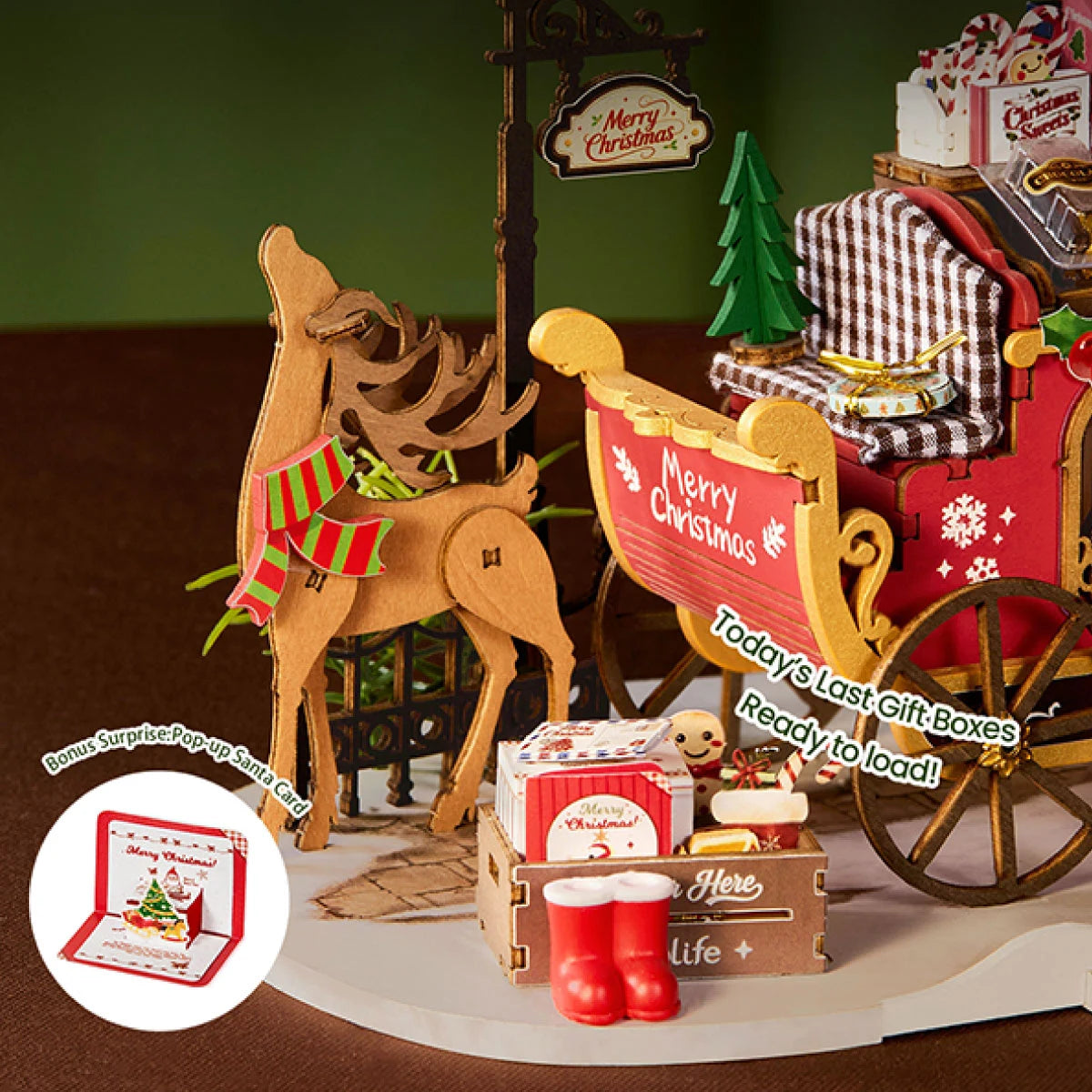 Close-up of the Reindeer Express wooden reindeer, gift crate, red boots, and pop-up Santa card