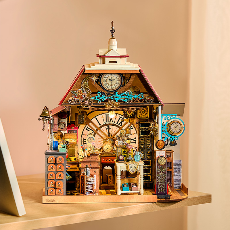 Front view of Clockwise Clocks DH104 on a shelf, showing its giant clock-face backdrop and hanging shop sign
