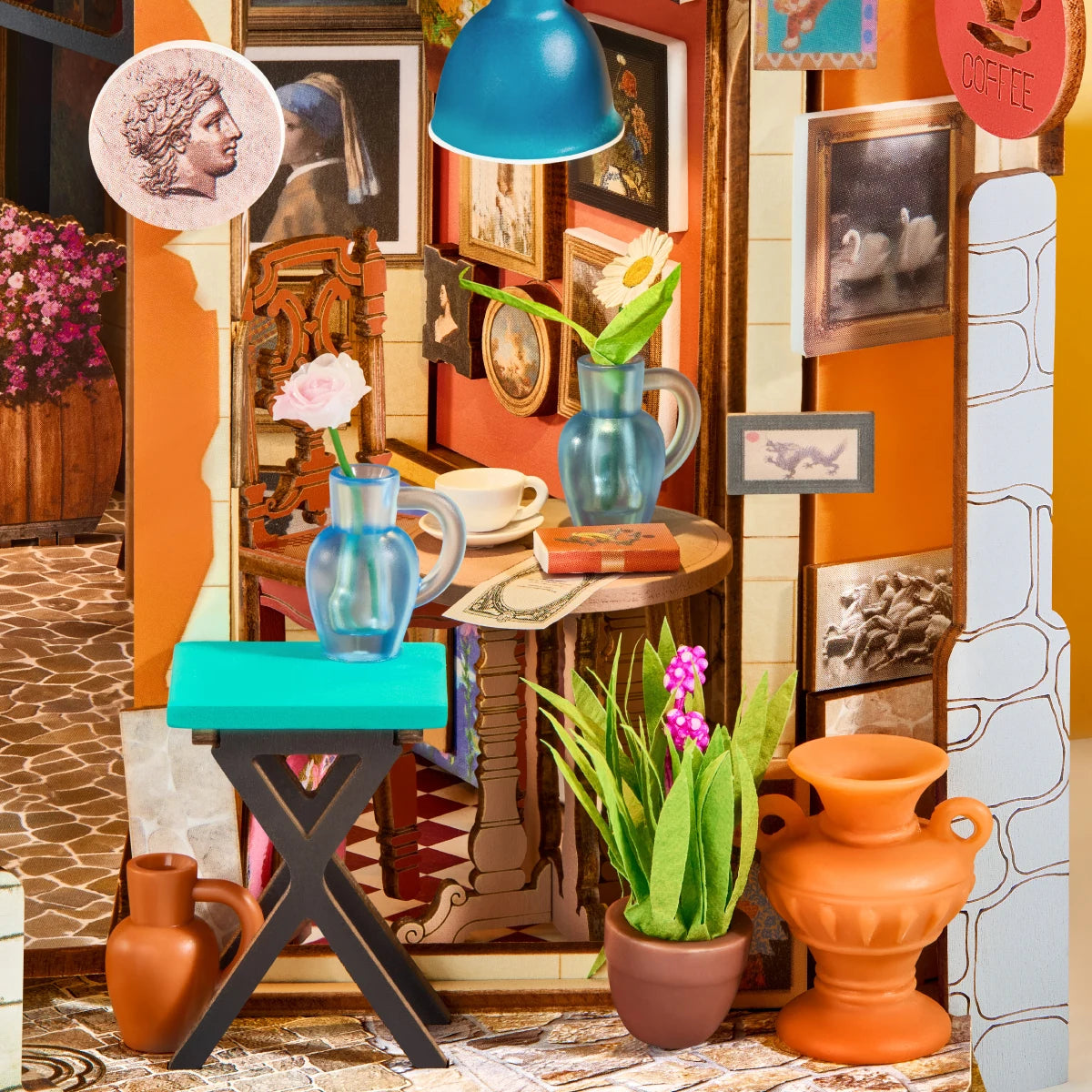 Close-up of the Romantic Art Lane caf&eacute; with framed paintings, pottery, flowers, and a blue pendant lamp